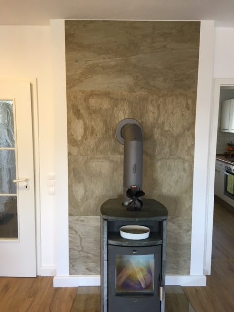 Eine Innenwand mit echter Steinfläche, wo ein Kamin davor steht  - Malermeister Marco Schubert | Wolfenbüttel