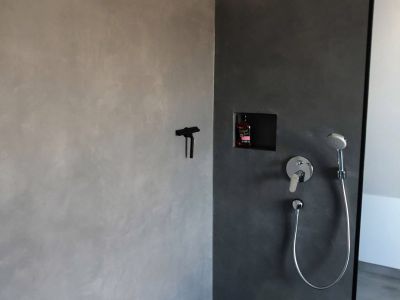 Sie sehen eine schwarze fugenlose Dusche aus Mikrozement