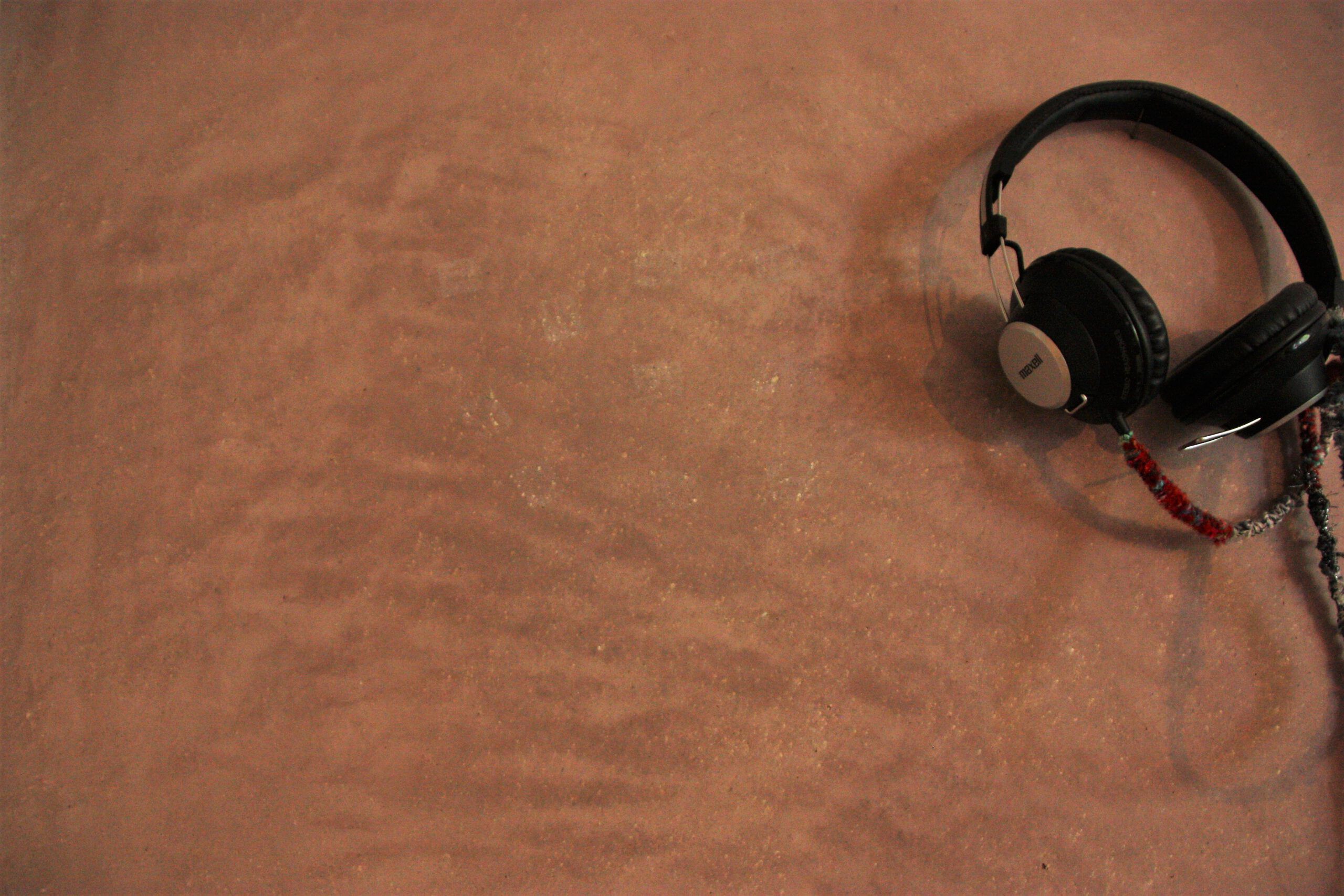 Eine Naturkalk-Wand in Bronze mit schwarzen Kopfhörern verziert - Malermeister Marco Schubert | Wolfenbüttel